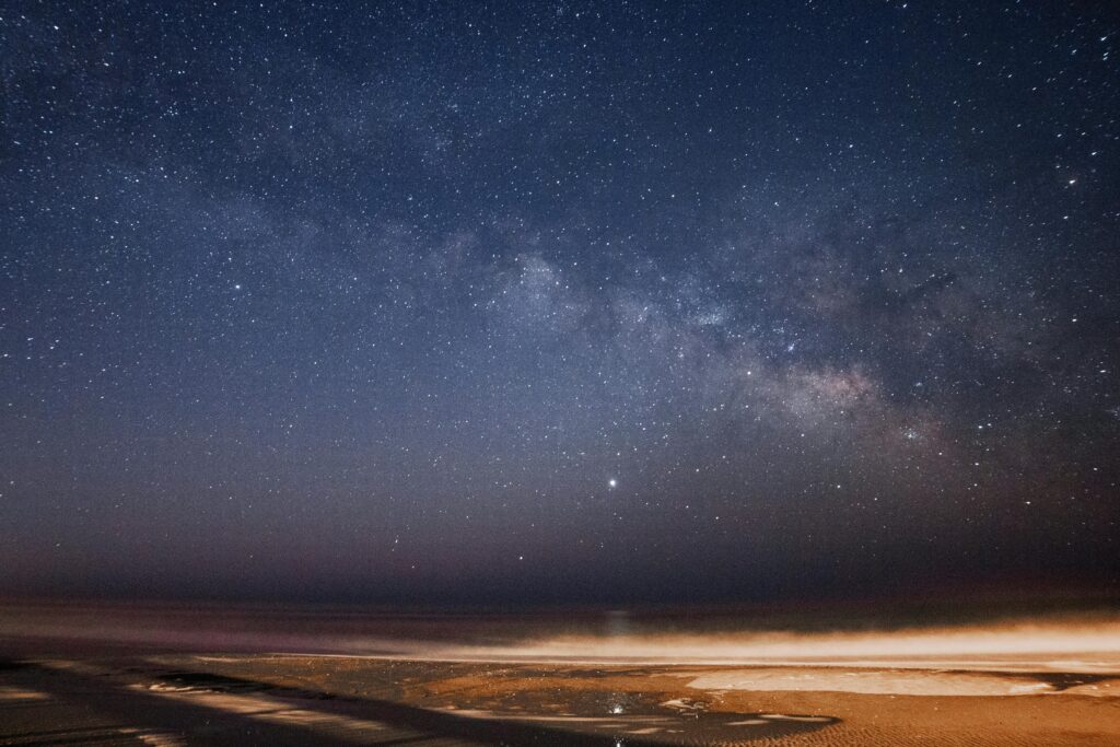 Captivating night view of the Milky Way galaxy over a calm ocean showcasing clear starry skies.